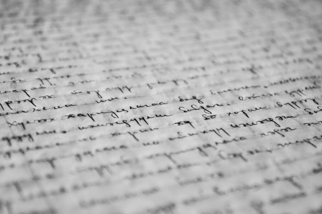 Close-up of vintage handwritten text on old paper, showcasing detailed penmanship and texture.