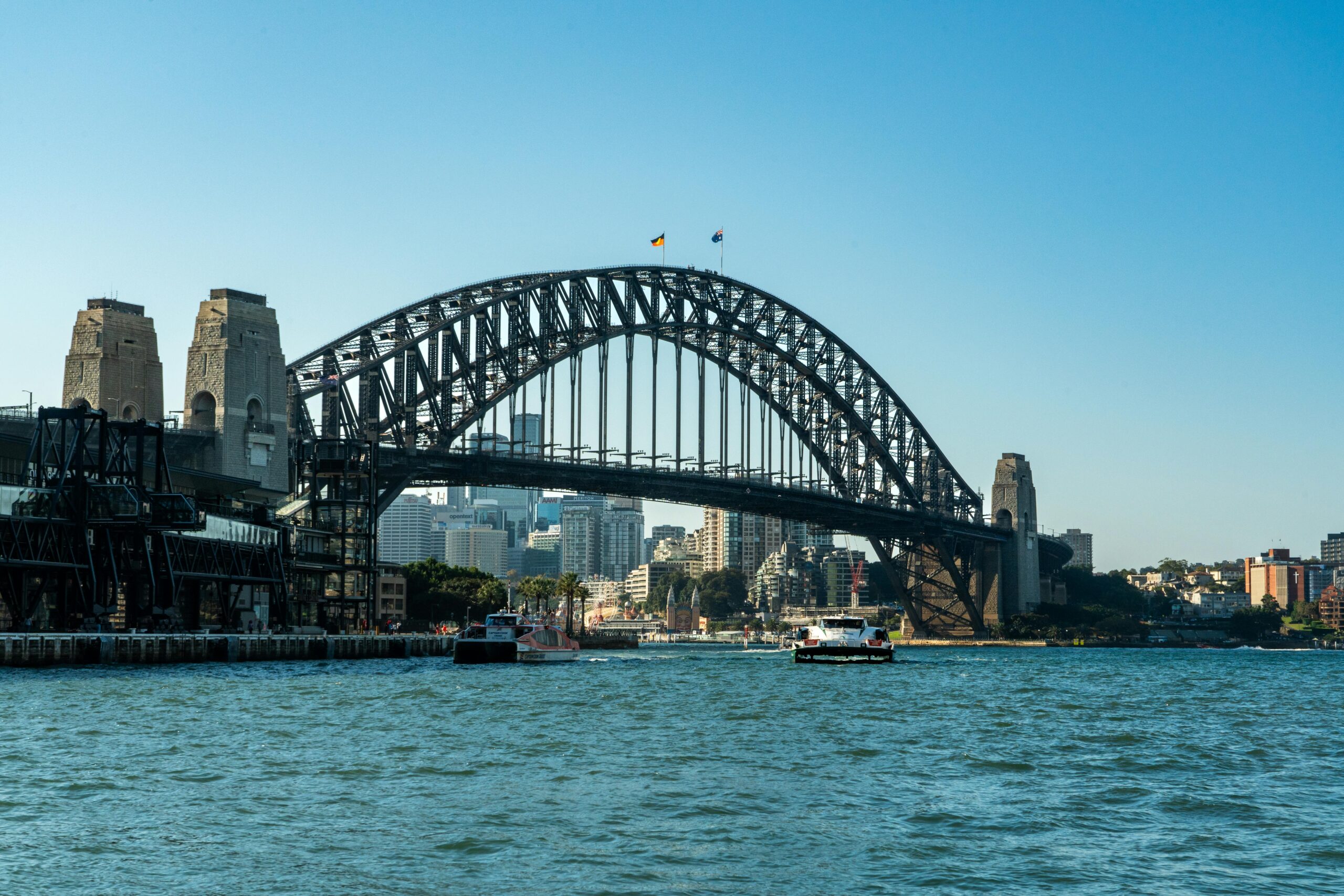 View of Sydney Harbour Bridge with city skyline and boats on a clear day.