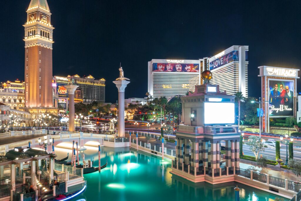 A stunning night view of Las Vegas Strip featuring illuminated landmarks and vibrant reflections.