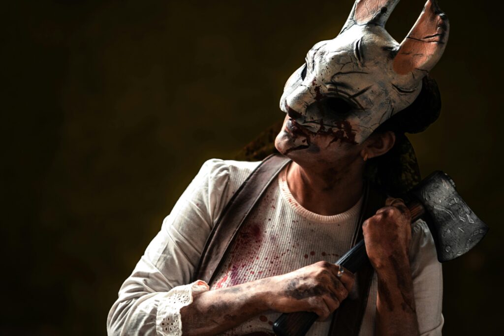 Creepy figure in rabbit mask holding axe, evoking horror theme. Perfect for Halloween content.