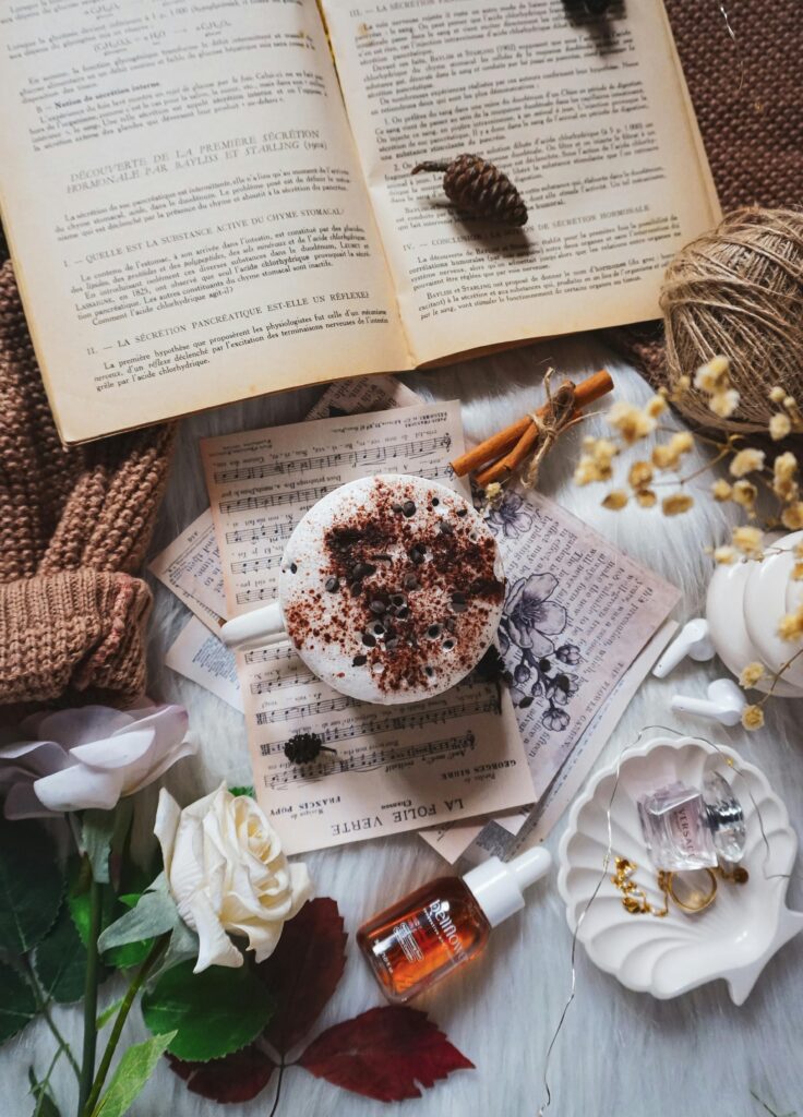 Flat lay of coffee, books, and autumn decor creating a warm and cozy atmosphere.