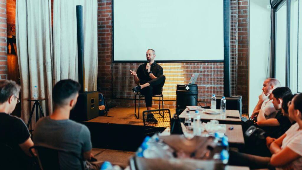 A business seminar with a speaker addressing an attentive audience in a modern conference setting.