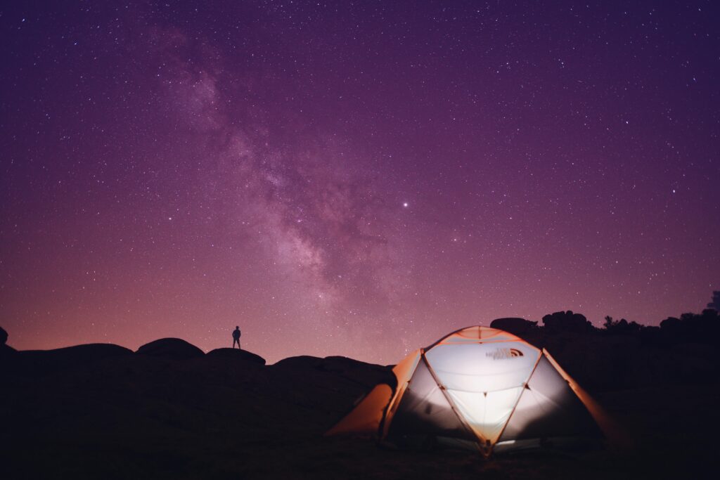 A captivating view of a night sky filled with stars above a glowing tent in Türkiye.