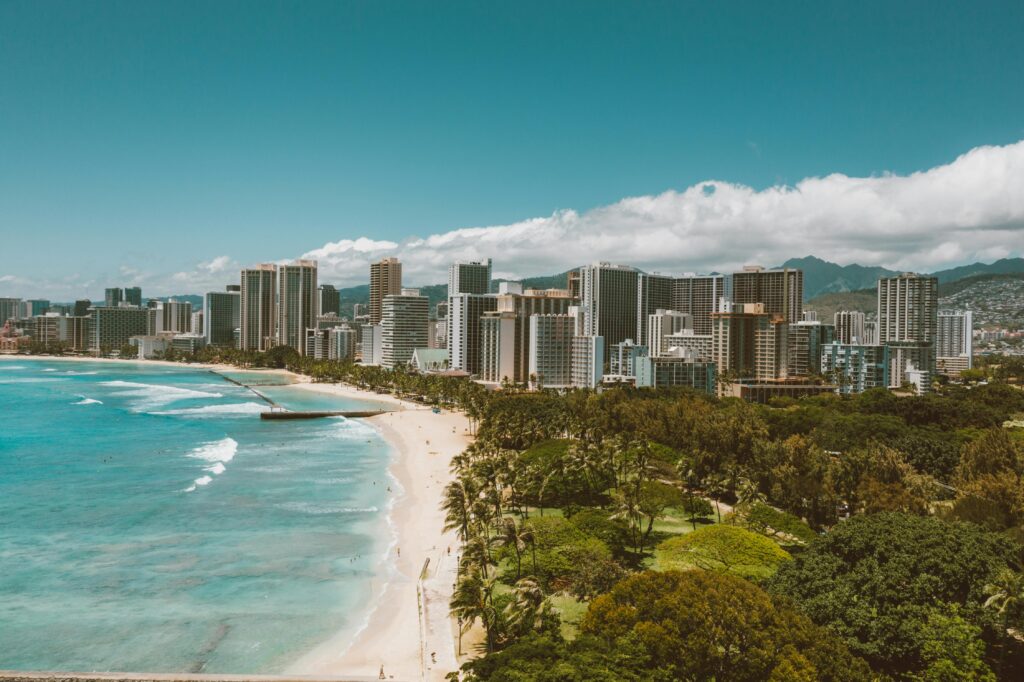 Stunning aerial view of Waikiki Beach and the Honolulu city skyline under clear blue skies.