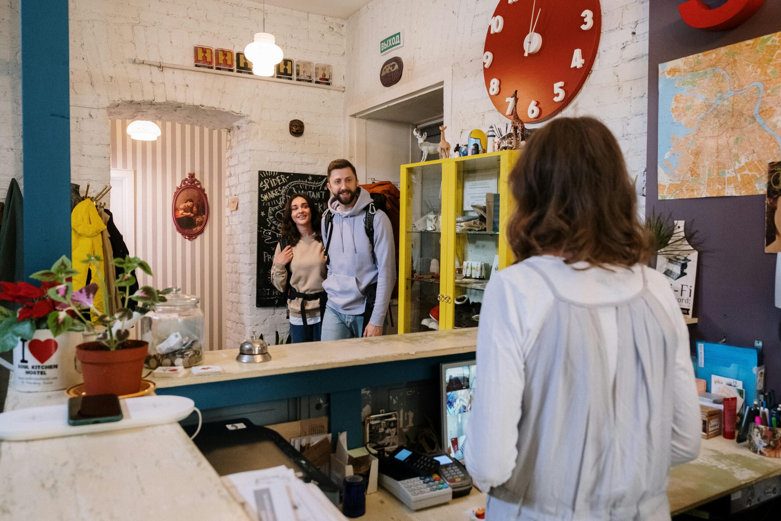 Friendly hostel reception area with travelers checking in, providing a warm and welcoming atmosphere.