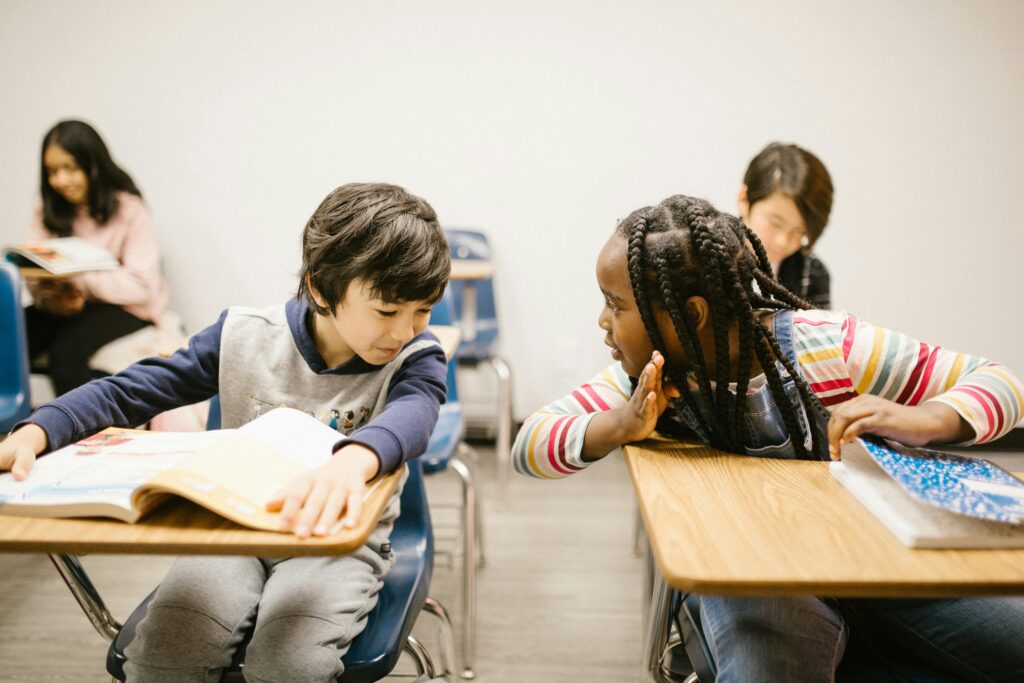 Elementary students chatting in a classroom setting, fostering communication skills.