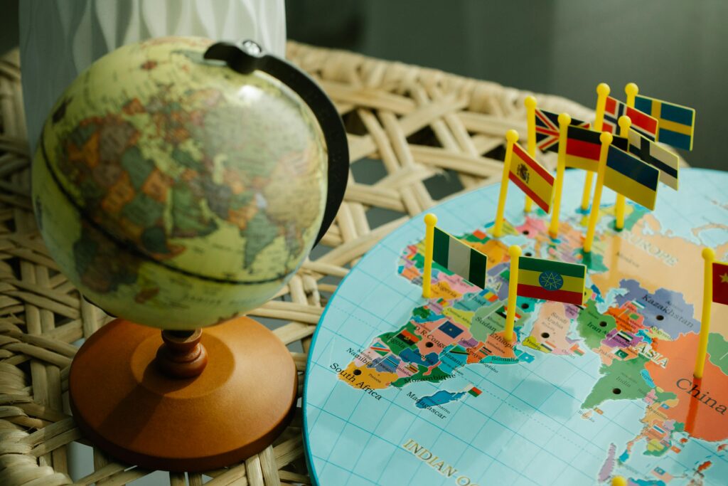 Decorative globe and map with various country flags indicating locations.