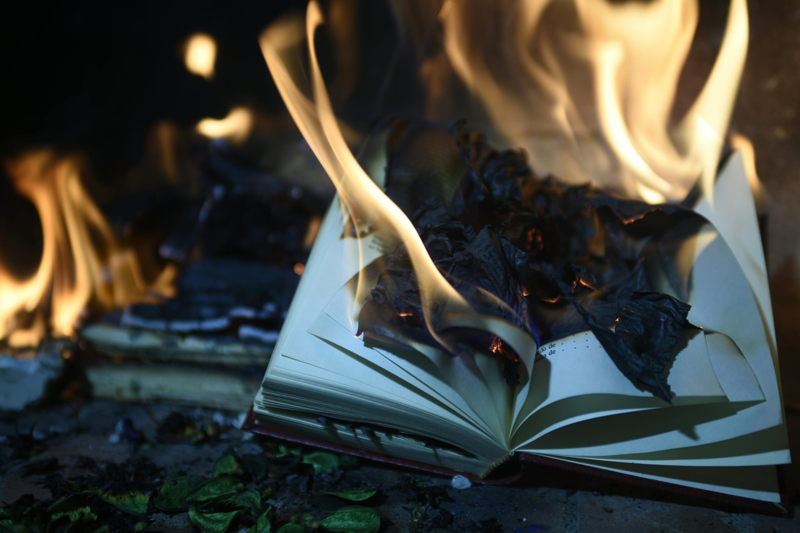 A book engulfed in flames, creating a dramatic scene of destruction and heat.