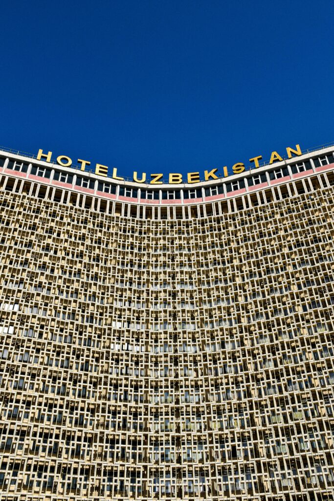 A striking view of the Hotel Uzbekistan building with a clear blue sky backdrop in Tashkent.