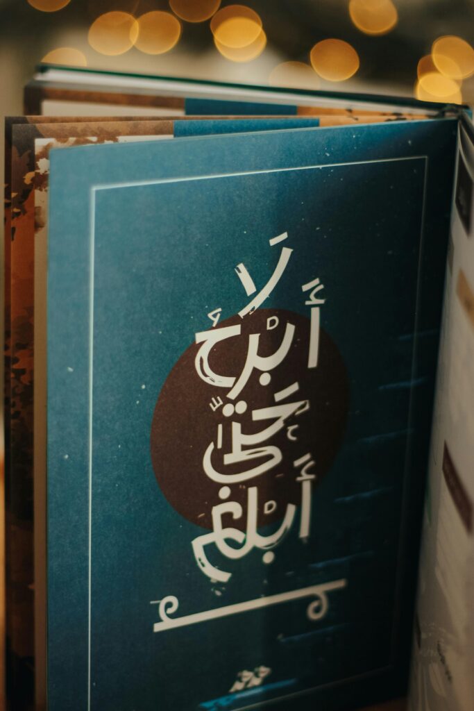 Close-up of a book page featuring Arabic calligraphy with bokeh effect.