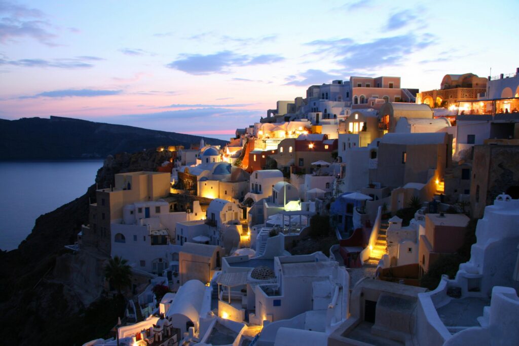 Beautiful illuminated cityscape of Santorini at dusk overlooking the Aegean Sea.