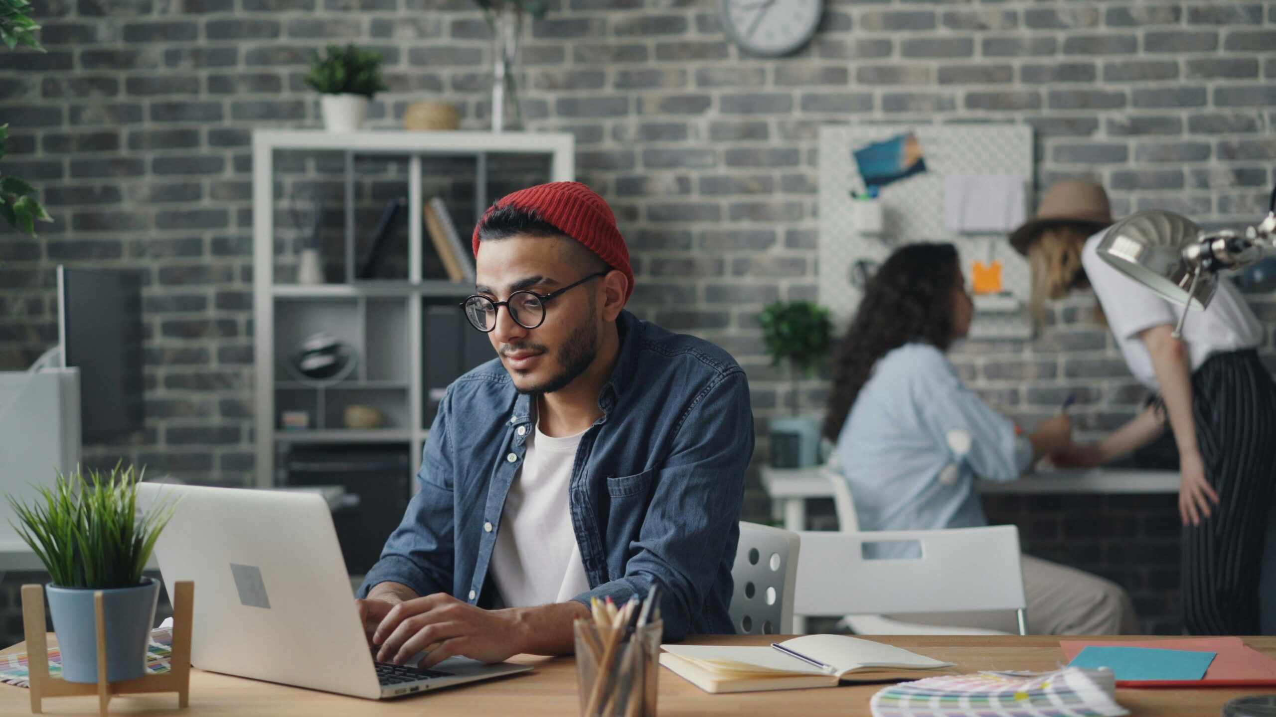 Multiethnic team working on laptops and projects in a modern and creative co-working office space.