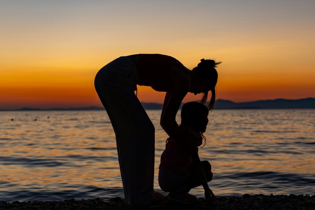 Heartwarming silhouette of a mother and child on a beach at sunset in Supetar.