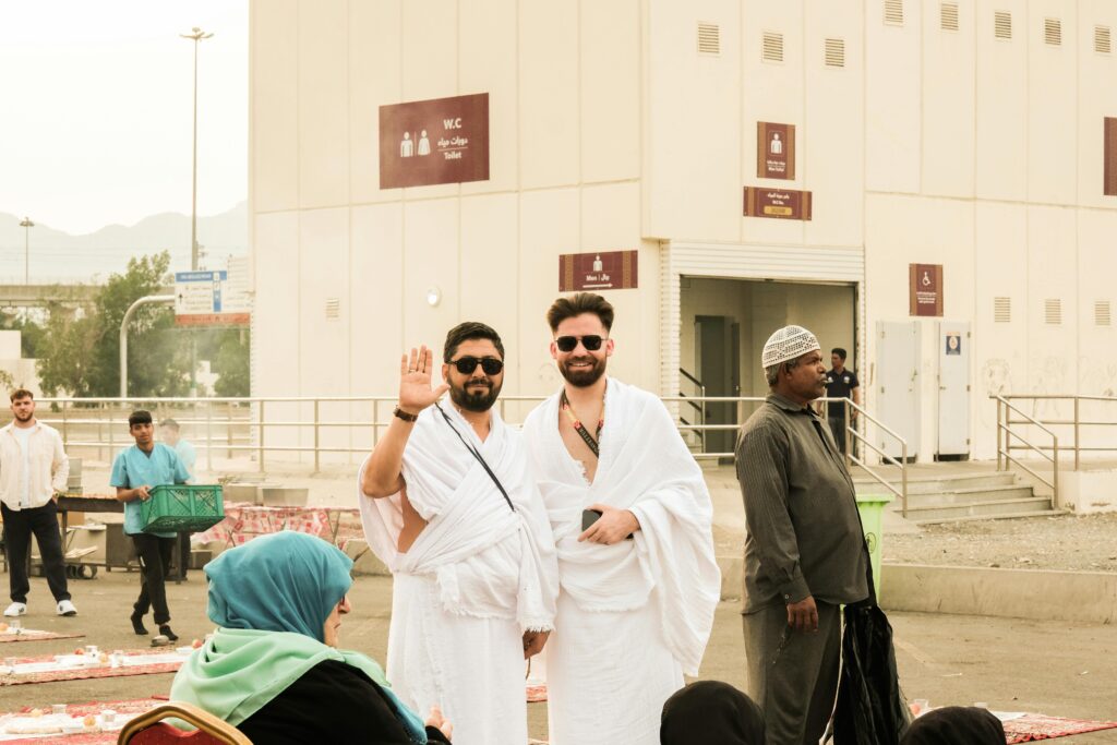 A candid photo of pilgrims wearing Ihram garments in Mecca, Saudi Arabia, during daylight.