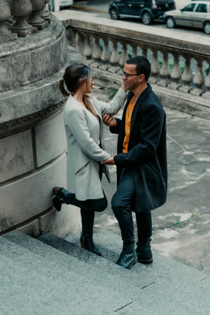 A loving couple sharing a moment on elegant stone stairs outdoors in Buenos Aires.