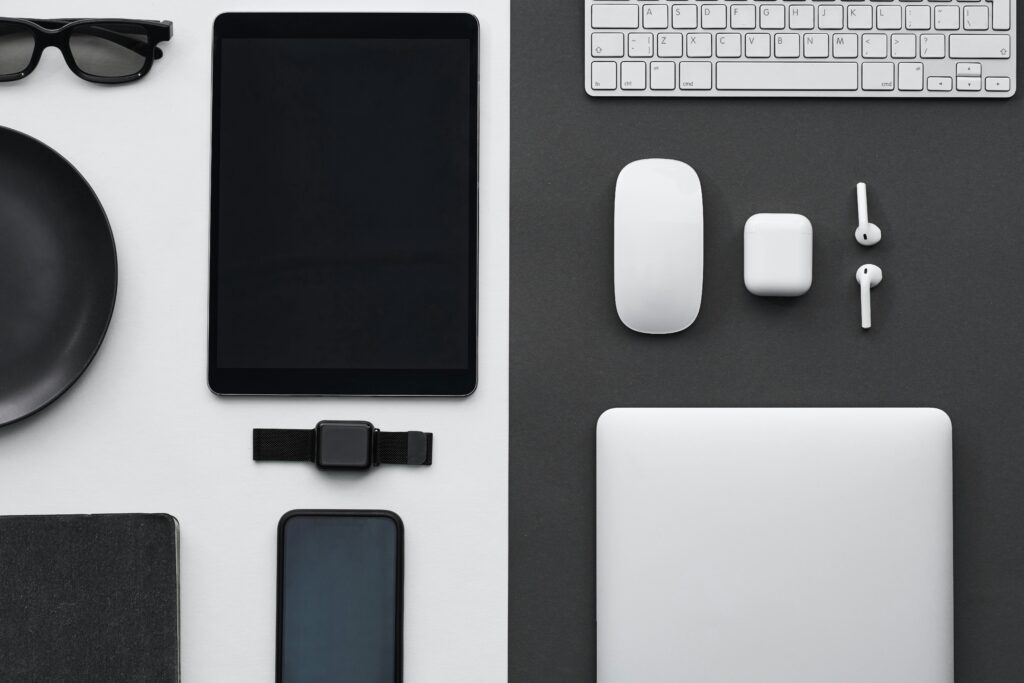 Stylish flatlay of modern tech gadgets including tablet, smartphone, smartwatch, and accessories.