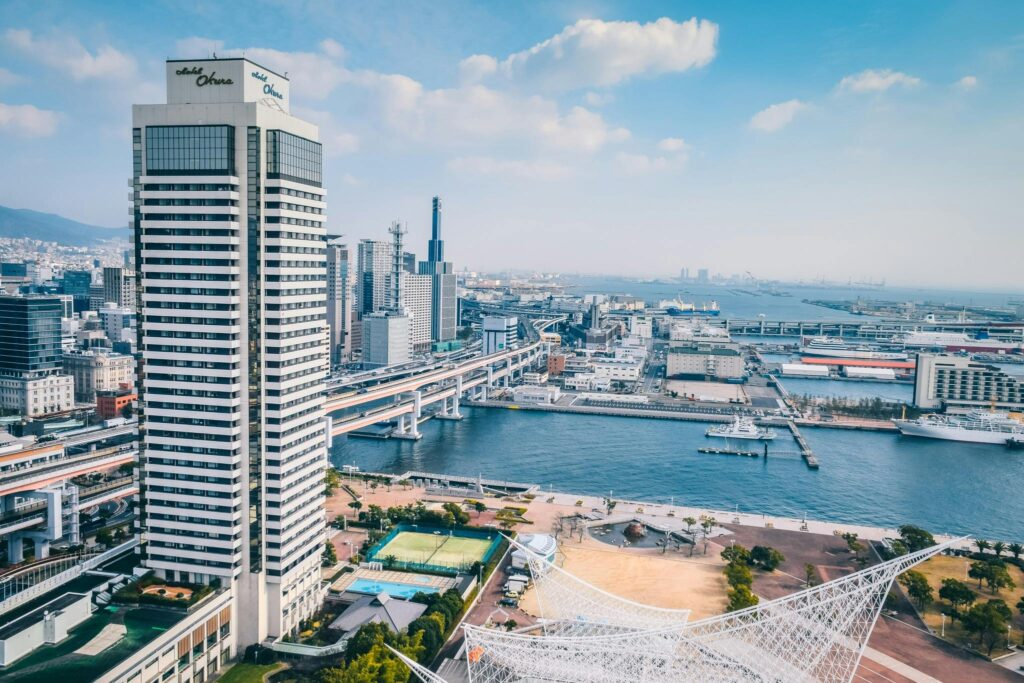 Elevated view of Kobe cityscape featuring modern architecture along the waterfront.