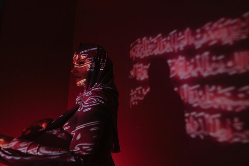 Artistic projection of Arabic scripts on a woman in a hijab, exuding mystery and cultural expression.