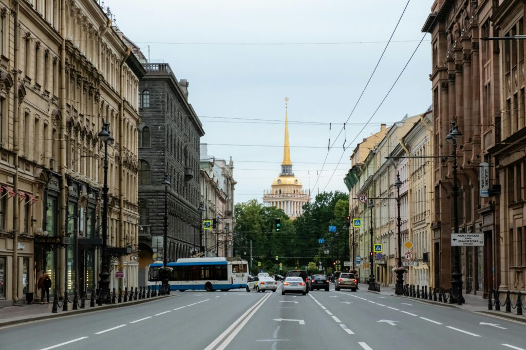 Street view of Saint Petersburg featuring the iconic Admiralty Building spire as cars commute down Nevsky Prospect.