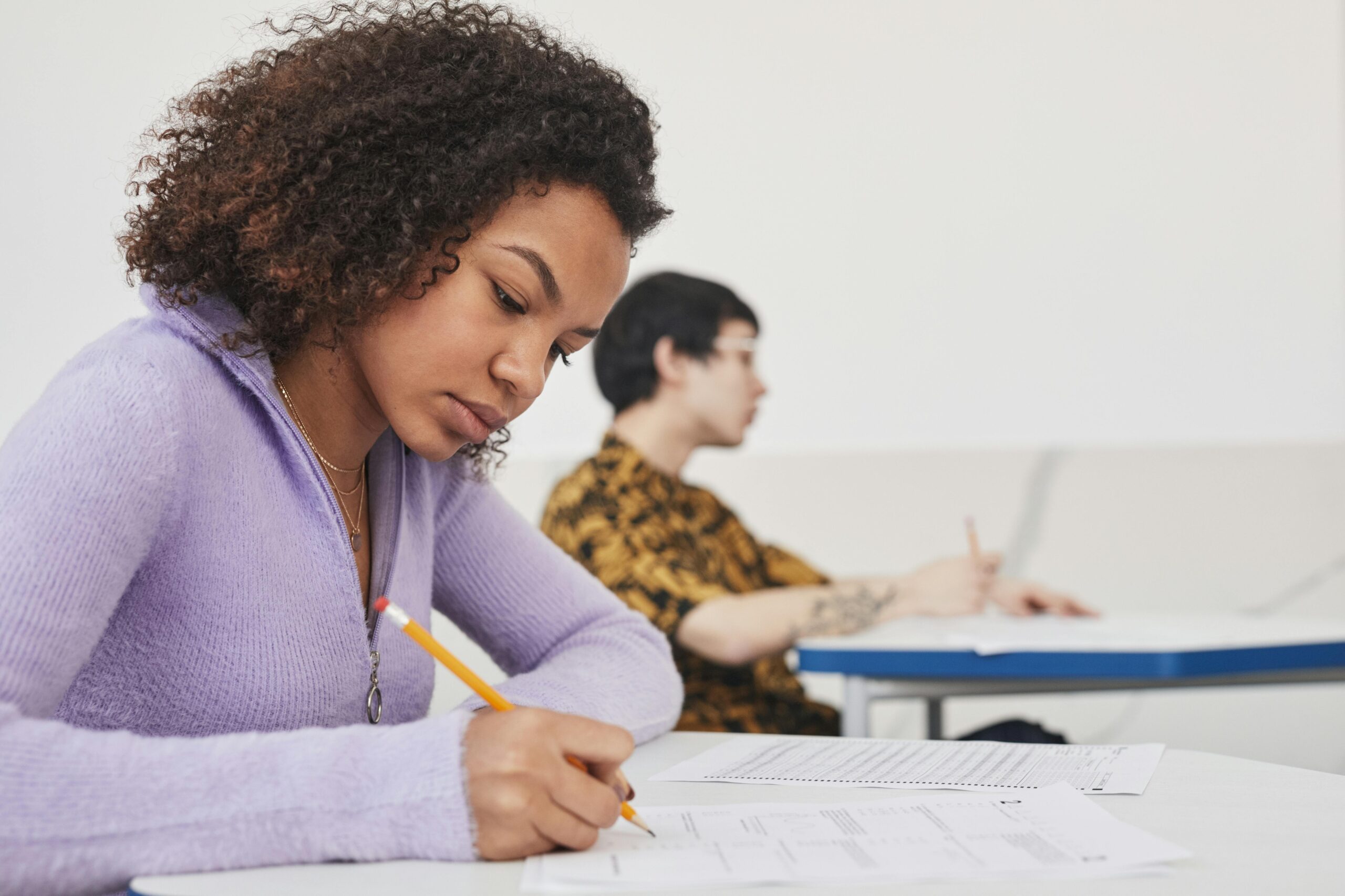 Young students concentrating on exams in a classroom, emphasizing focus and education.