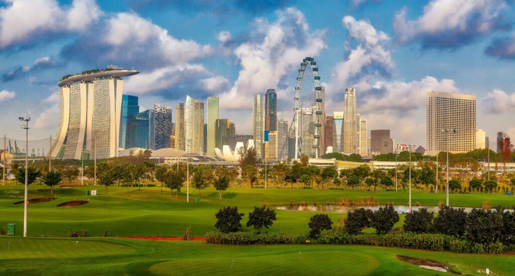 Stunning view of Singapore's skyline including Marina Bay Sands and a lush golf course in the foreground.