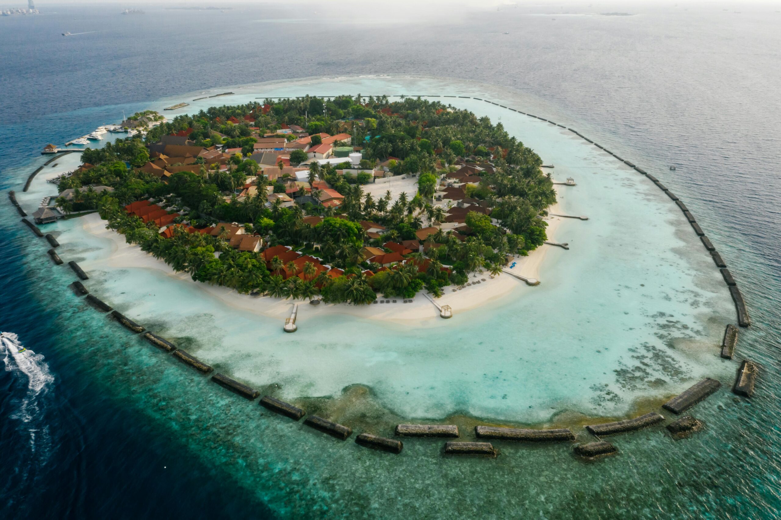 Stunning aerial shot of a lush island resort surrounded by turquoise waters.