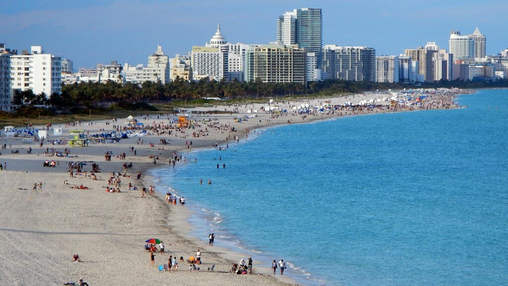 A vibrant beach scene with Miami's skyline backdrop, ideal for urban tourism imagery.