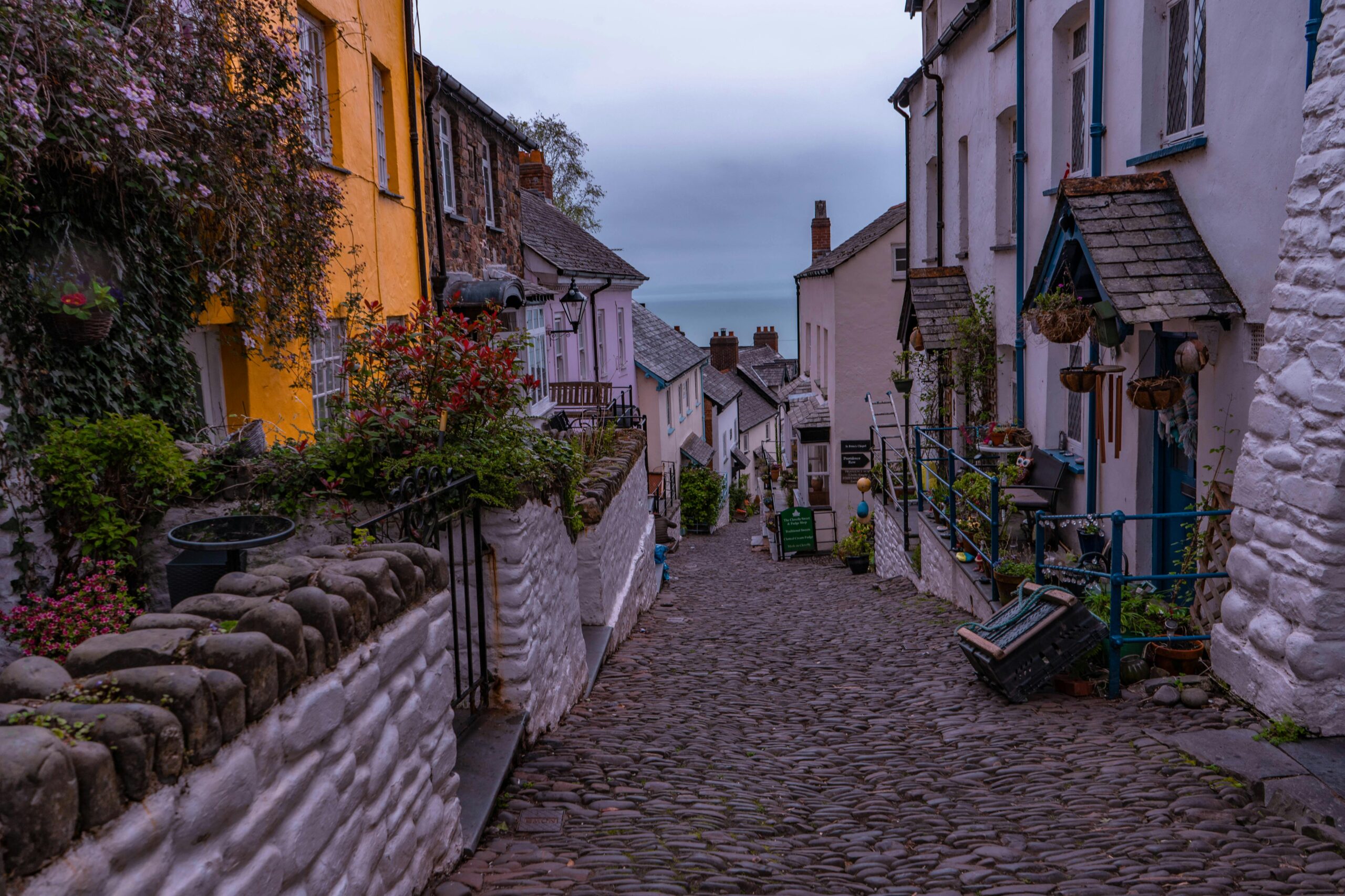 Charming cobblestone street with colorful houses in Clovelly, England, exuding quaint English village charm.