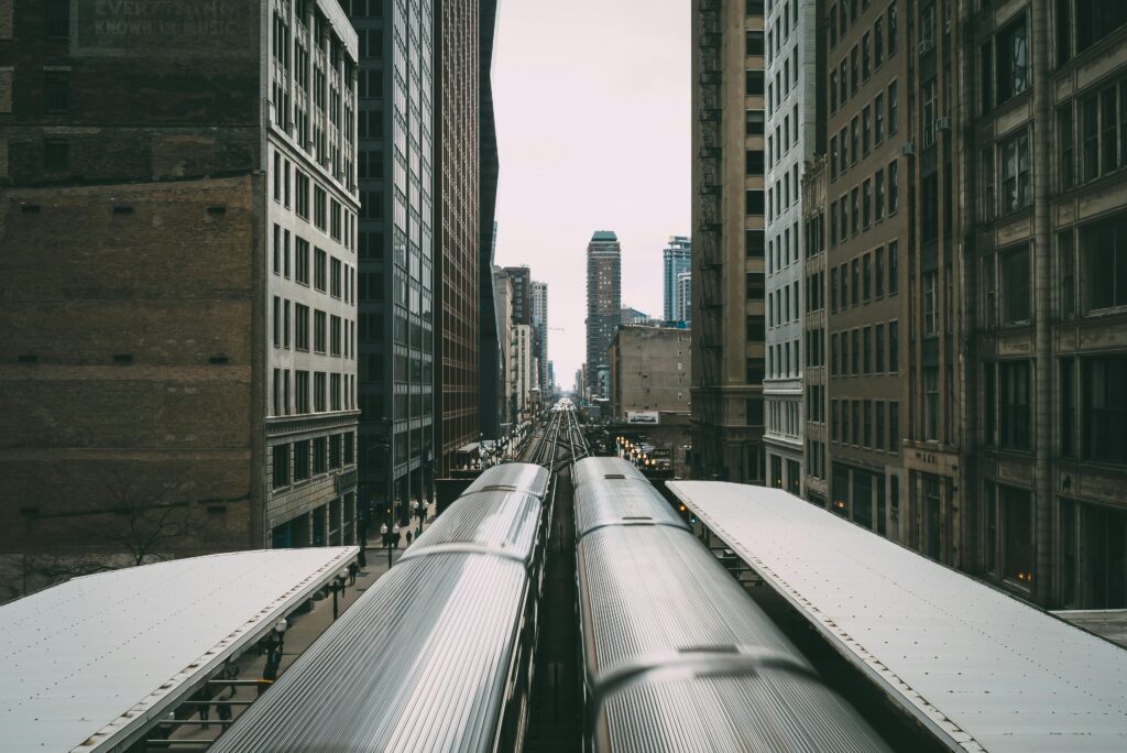 Symmetric view of trains amidst Chicago skyscrapers, showcasing urban transport.