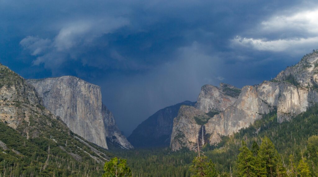 A breathtaking view of Yosemite Valley with dramatic skies and iconic cliffs before a storm.
