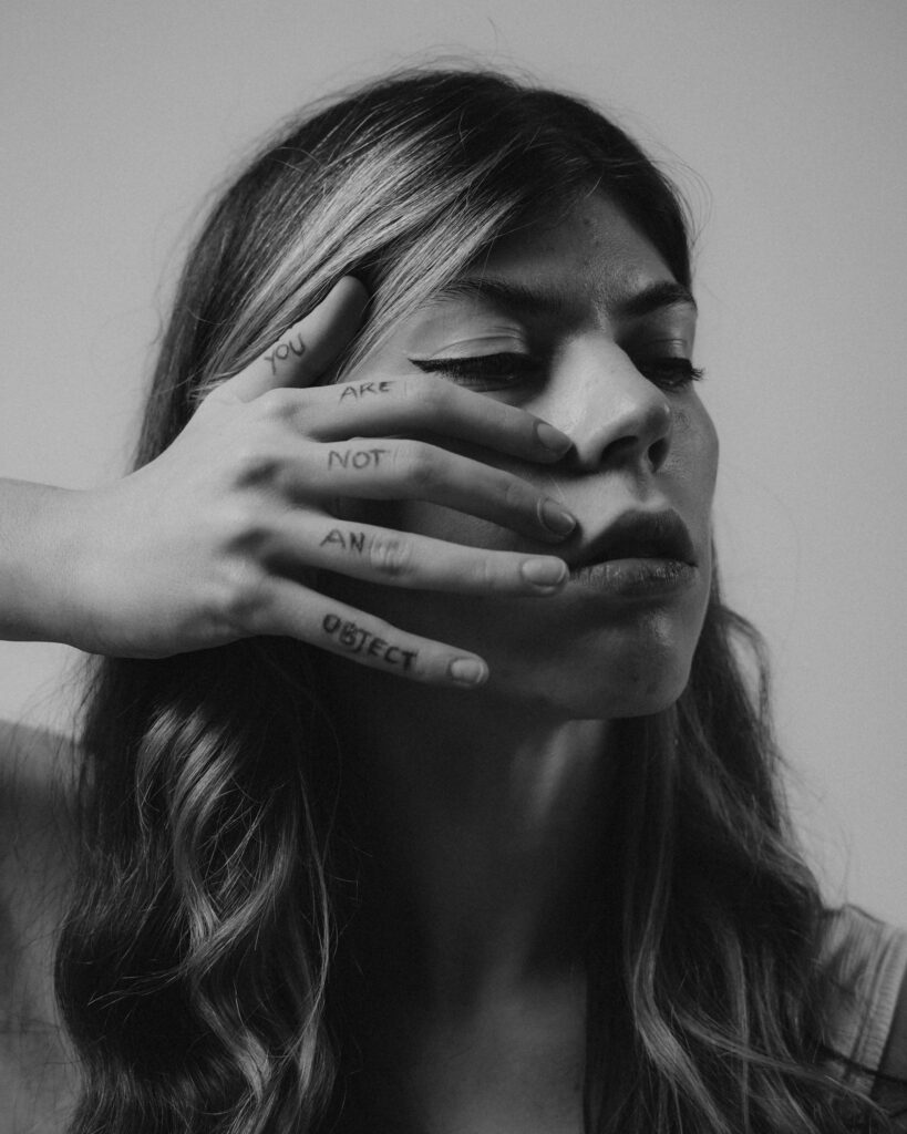 Black and white portrait with a hand displaying the message 'You Are Not An Object'.