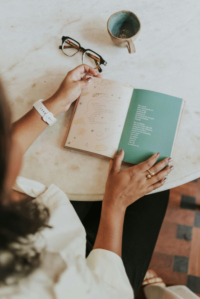 A woman enjoying a poetry book with coffee on a marble table, capturing serene morning vibes.