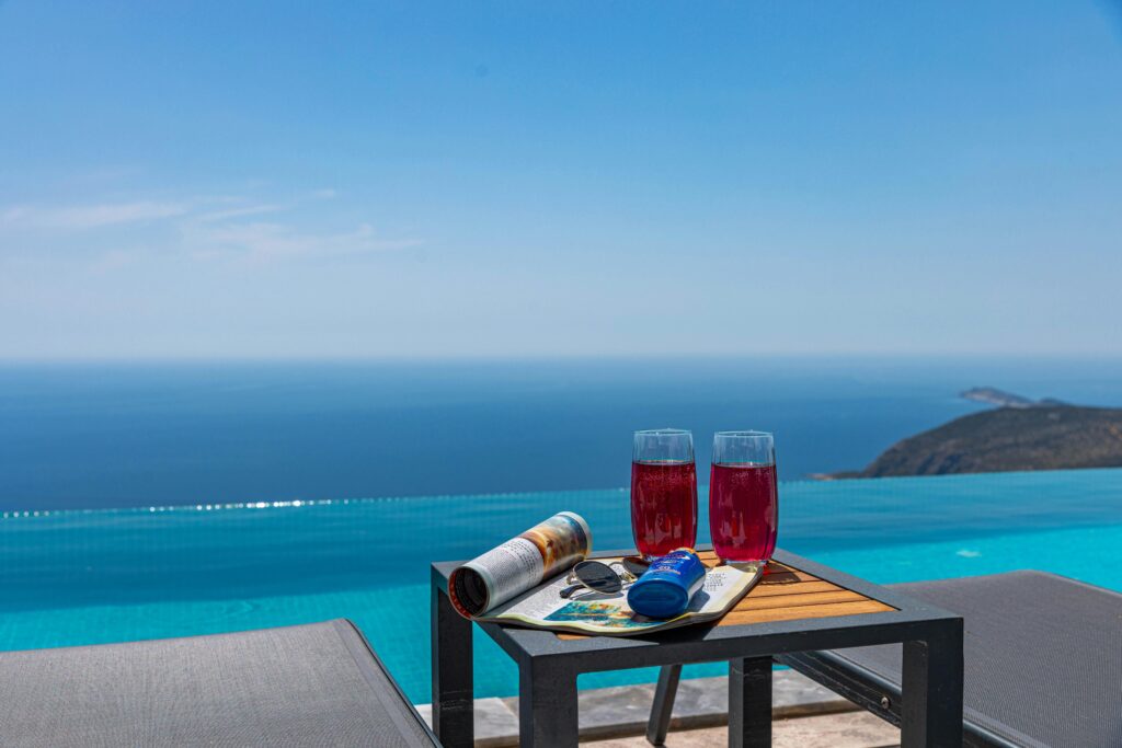 Serene ocean view from an infinity poolside with drinks and relaxation setup.