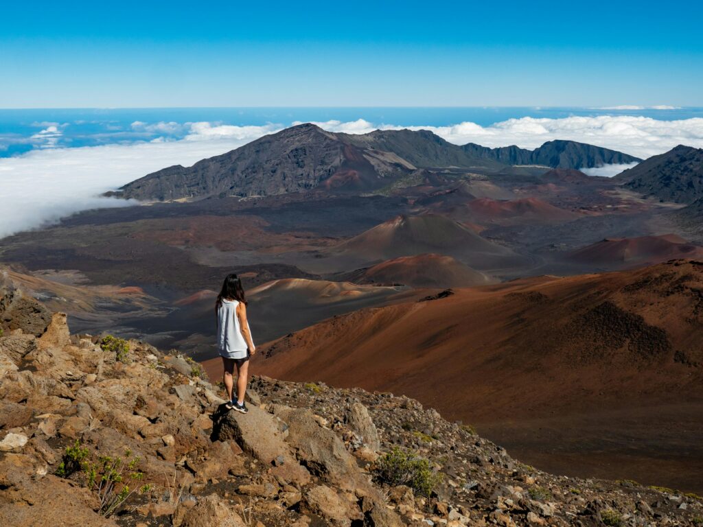 Woman hiking in Haleakalā National Park, enjoying scenic volcanic landscape in Maui, Hawaii.