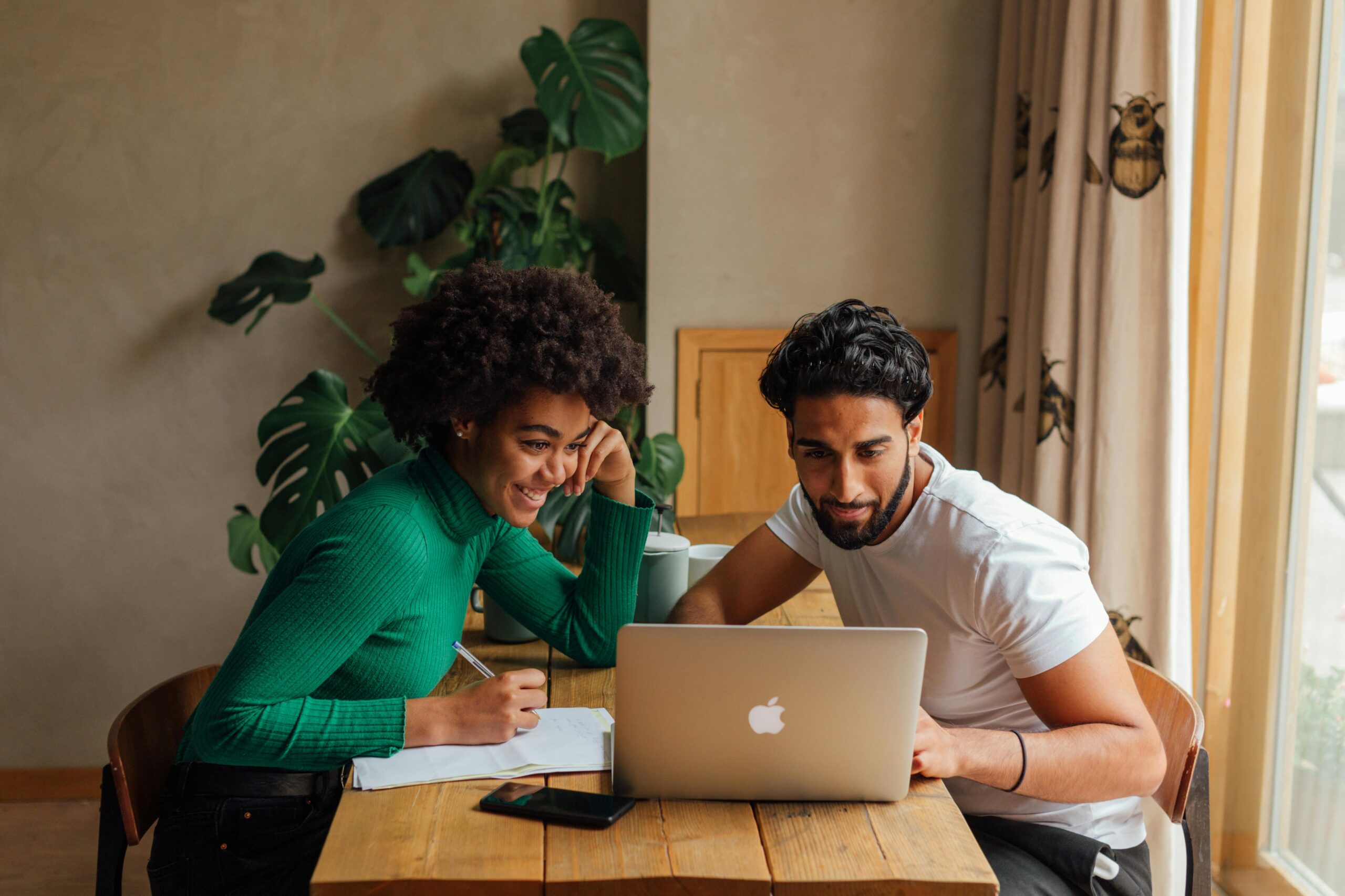 Young professionals working together on a project with a laptop, fostering teamwork and collaboration.