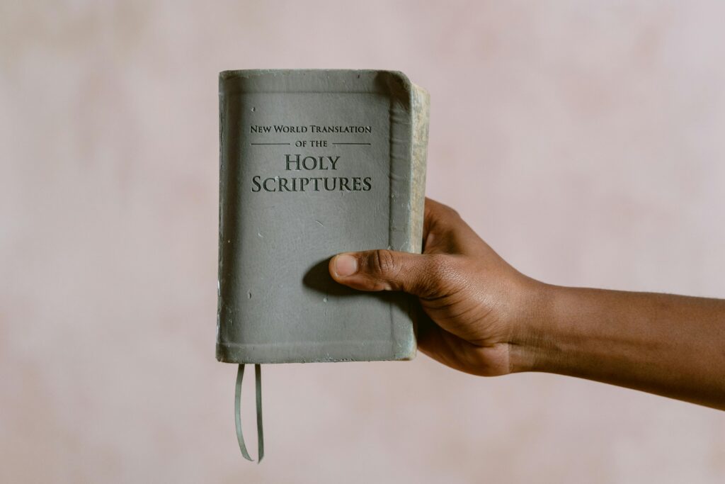 Close-up image of a hand holding the New World Translation of the Holy Scriptures book.