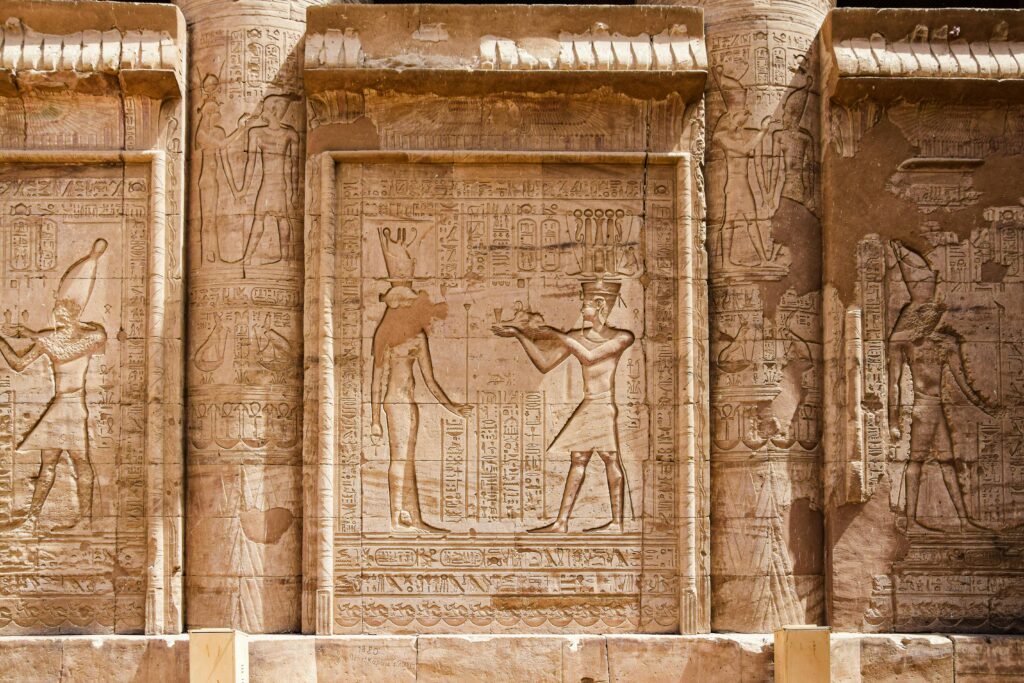 Engraved stone reliefs with intricate hieroglyphs from ancient Egyptian civilization.