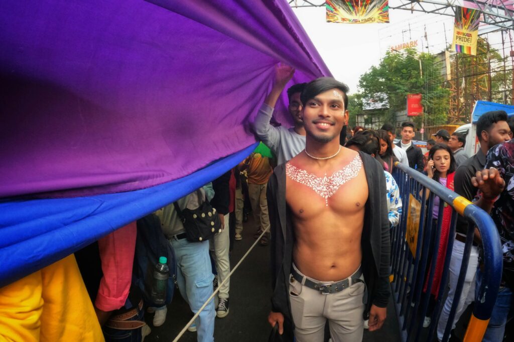 Vibrant celebration at the Kolkata Pride Walk with colorful flags and joyful participants.