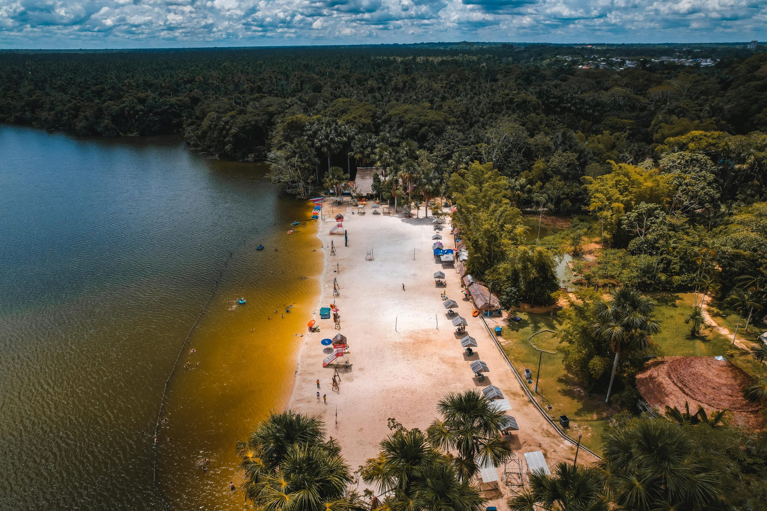 Stunning aerial shot of a beach on Laguna Quistococha, surrounded by lush forest in Iquitos, Peru.