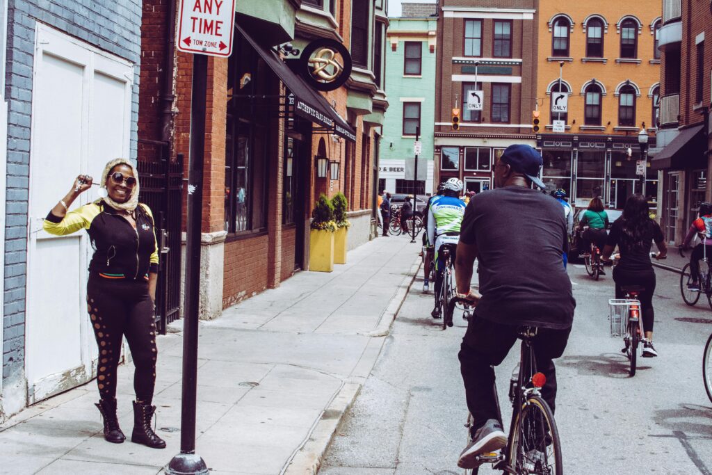 Vibrant street shot of cyclists and a standing woman in Cincinnati, OH.