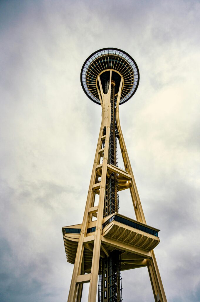 The Seattle Space Needle reaching into a cloudy sky, showcasing its unique design and towering presence.