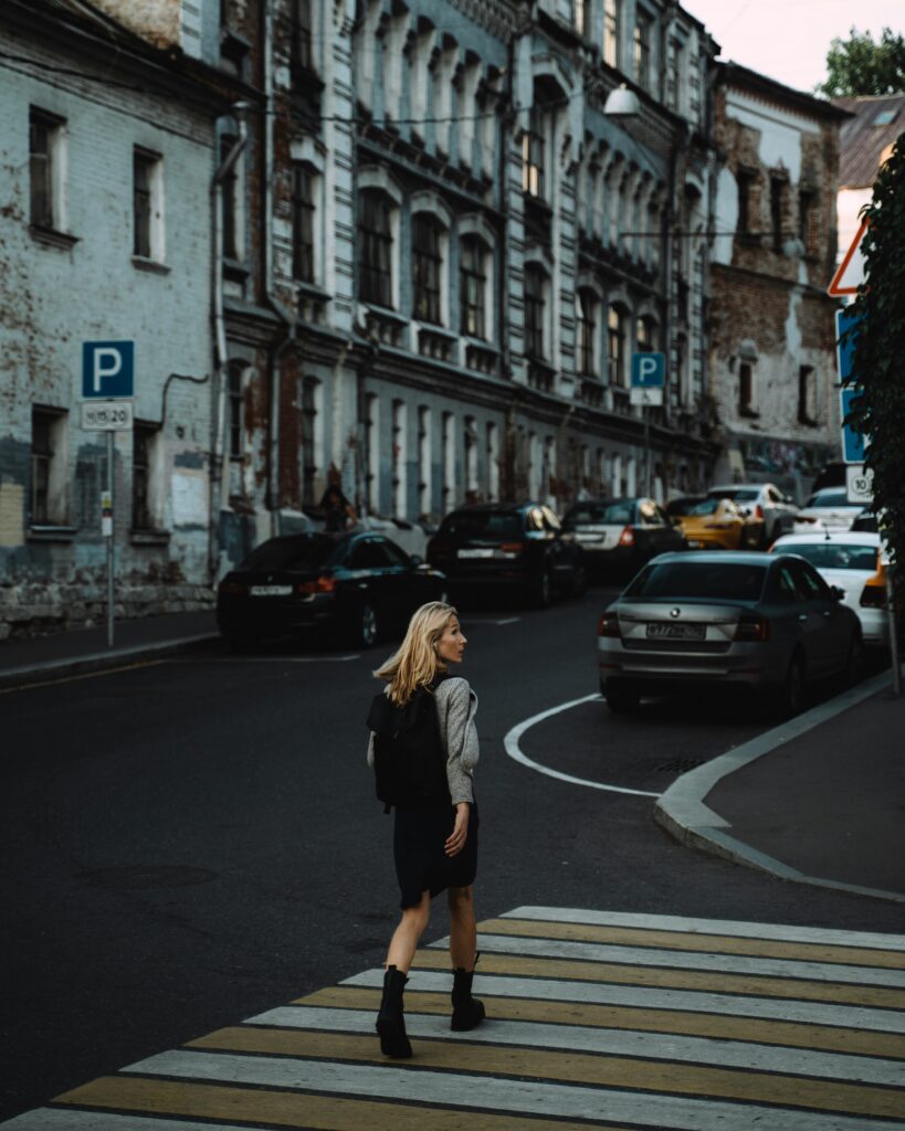 A woman confidently crosses a zebra crossing in a historic area of Moscow, Russia, providing a lively urban scene.