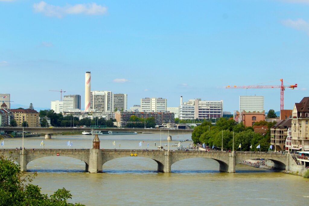 Beautiful view of Basel's historic bridge over the Rhine River with city skyline in the background.