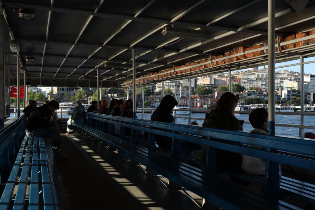Passengers on a ferry in Istanbul enjoy the city skyline. The scene captures urban life and maritime travel.
