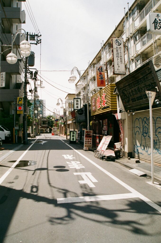 Empty street scene in Tokyo, Japan showcasing traditional Japanese shopfronts and urban architecture.
