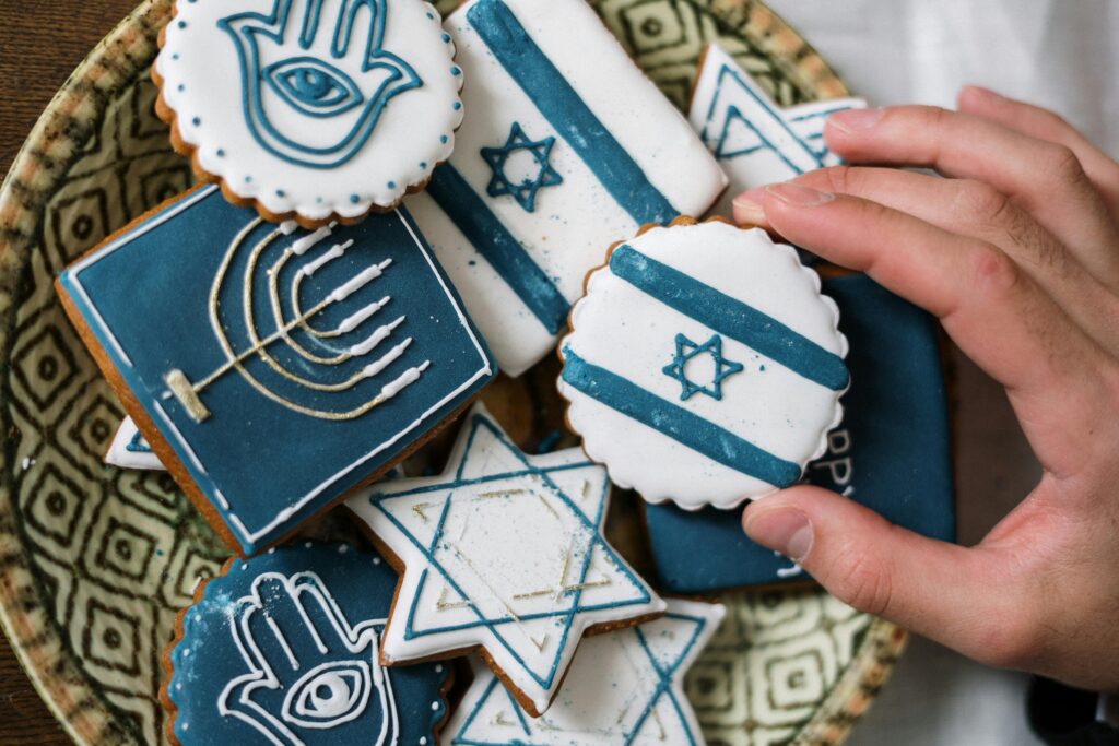 Close-up of Jewish themed cookies featuring Hamsa, Menorah, and Star of David.