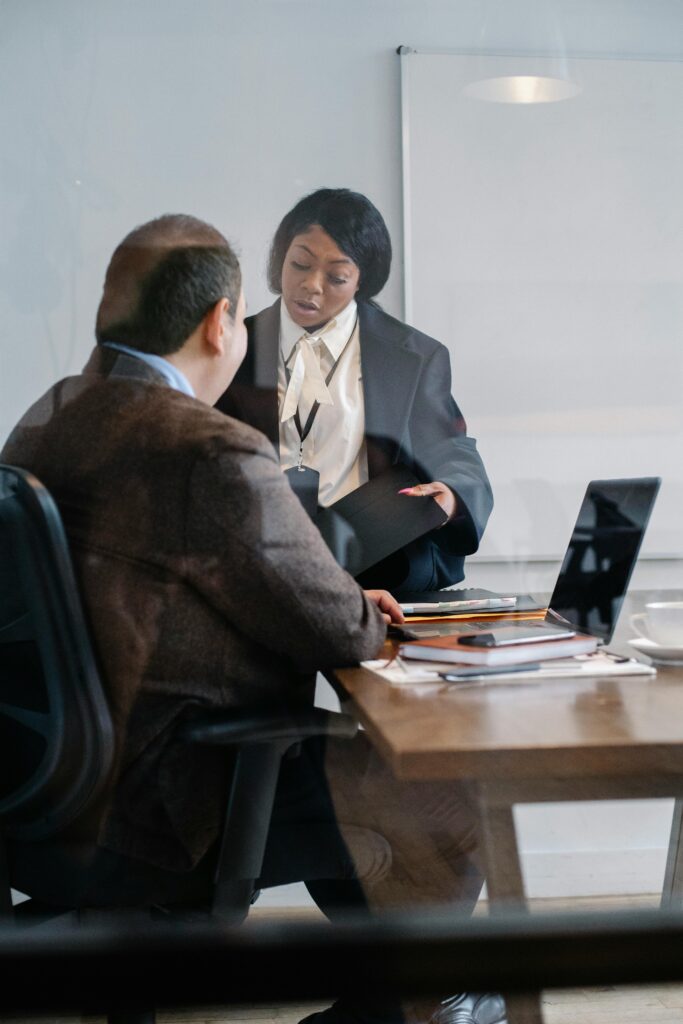 Two professionals engage in a strategic discussion at a modern office desk.