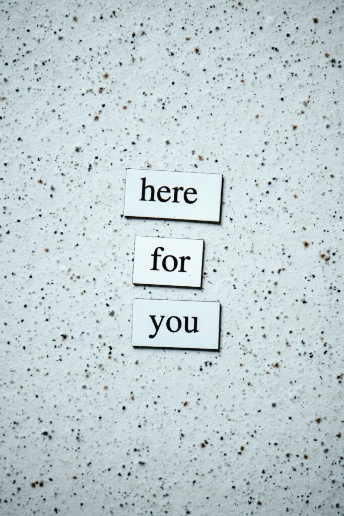 Motivational text 'here for you' on a speckled surface, conveying support.