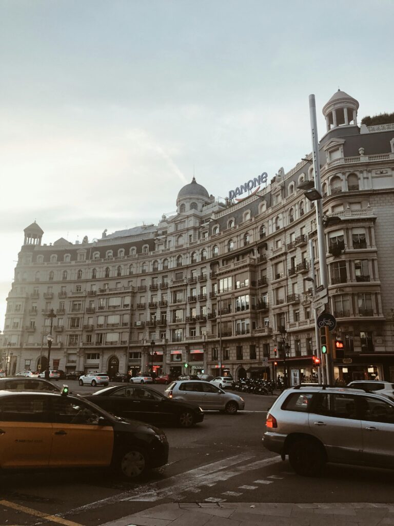 Capture of a historic building and bustling city scene in Barcelona's urban landscape at sunset.