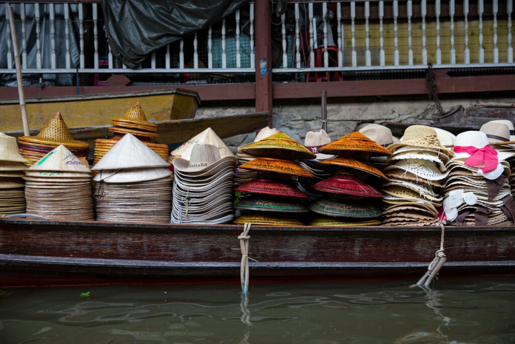 A vibrant display of traditional hats stacked on a boat in an Asian floating market.
